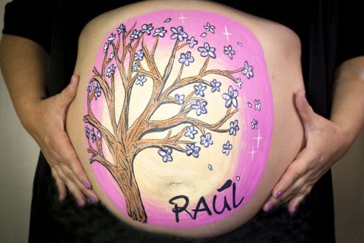 Girl drawing on belly of pregnant woman