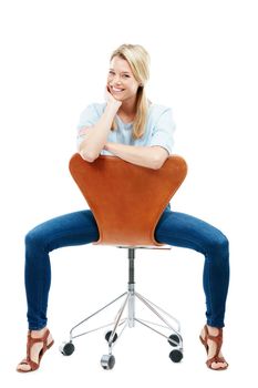 Im taking a casual approach to the day. Studio portrait of a happy young woman sitting on a chair against a white background.