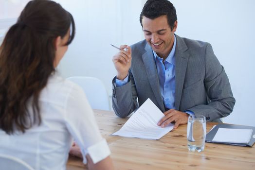 Youre very experienced. A young businessman going over a candidates impressive resume at a job interview.