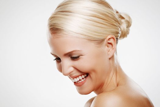 Her positive attitude keeps her glowing. Isolated shot of a laughing blonde woman with copyspace.