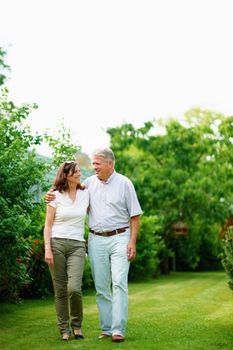 Retirement means more quality time together. Full length shot of a mature couple walking in their yard.
