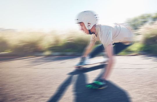 Skate, blurred motion and speed with a sports man skating on an asphalt road outdoor for recreation. Skateboard, soft focus and fast with a male athlete or skater training outside on the street