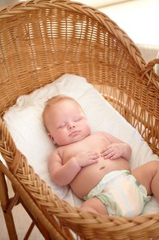 Catching a midday nap. Cute baby boy sleeping peacefully in his bassinet.
