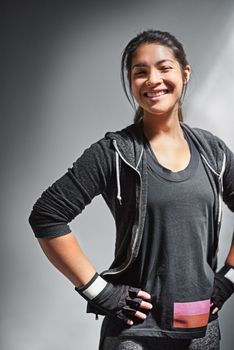Making time to exercise. Portrait of a fit young woman in sports clothing posing against a gray background.