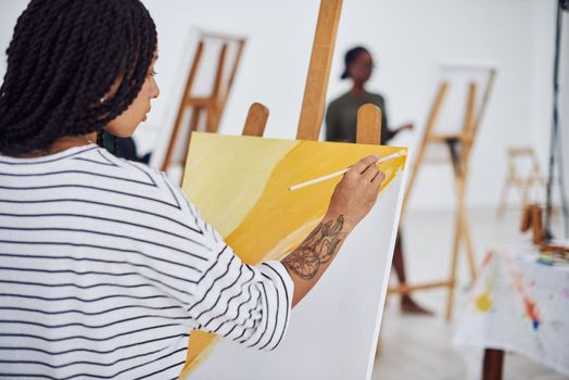 Painting is a way of connecting with your inner self. a beautiful young woman painting in a art studio.