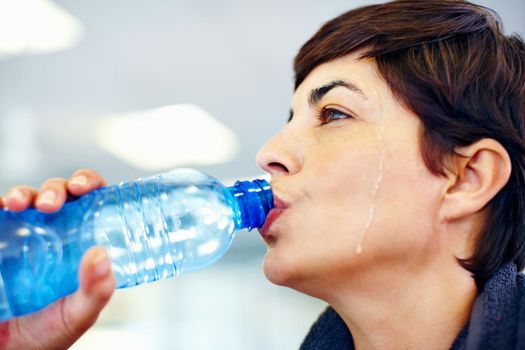 Woman hydrating after exercise. Closeup of fitness woman drinking water after workout.