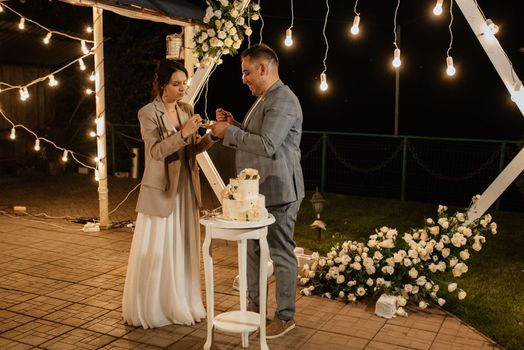 newlyweds happily cut and taste the wedding cake