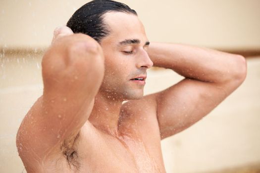 Feel the freshness. a handsome young man enjoying a refreshing shower.