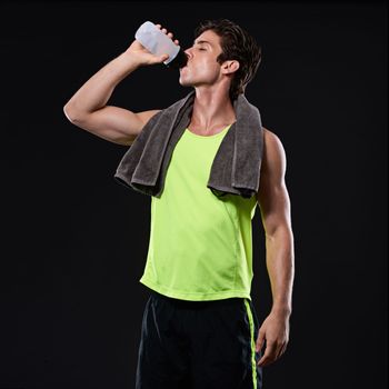 Time to refuel. Studio shot of a handsome young man in sportswear.