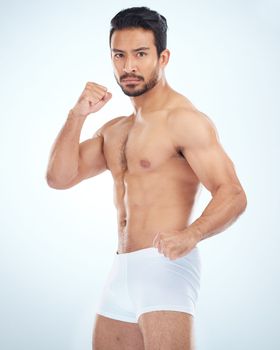 Fitness, underwear and man with fist, studio or martial arts with muscle, wellness and strong by backdrop. Model, mma and shirtless with balance, posture and portrait by studio background with focus