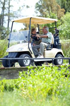 Retired and enjoying lifes small pleasures. A mature couple discussing their last hole while driving a golf cart.
