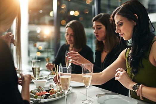 Women friends, dinner and restaurant with champagne, sushi or toast in bonding, happiness or celebration. Woman group, food and party for fine dining, friendship or conversation in night to celebrate