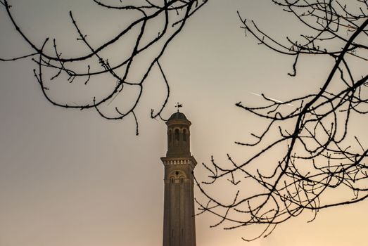 London, UK - Feb 22, 2019 : The beauty of the church tower that looks through the branches of trees and the sky.
