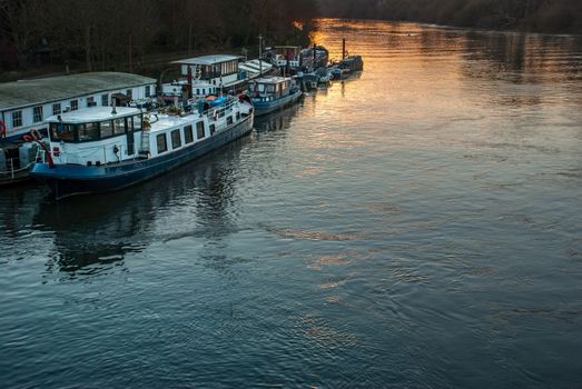 Many boats that are parked on the Thames