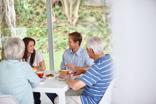 Food taste better when you eat it with your family. a family eating together at home.