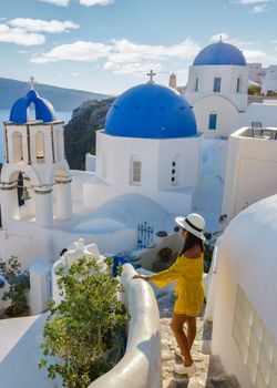 Happy Asian woman visit Oia Santorini Greece during summer with whitewashed homes and churches