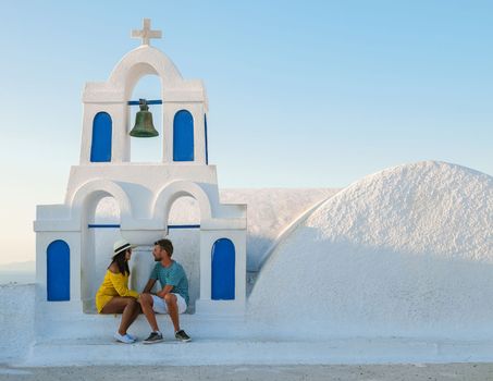 Young couple tourist visit Oia Santorini Greece during summer with whitewashed homes and churches