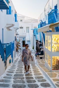 Tourist at the streets of Mykonos Greek village in Greece, colorful streets of Mikonos village