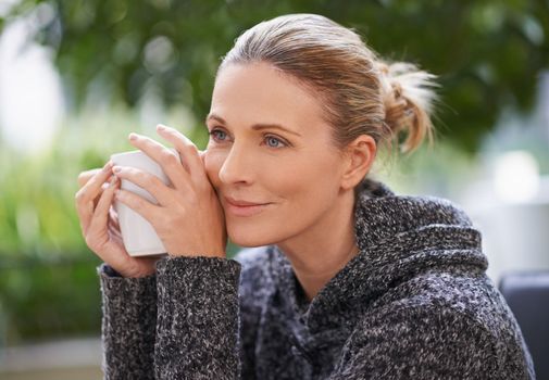 Happiness is a soothing cup of goodness. an attractive mature woman enjoying a hot drink at a spa.