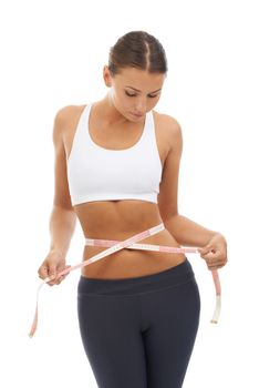 Perfect the way she is. A young woman measuring her slim waist and charting her weight loss progress.