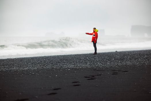 Man watching the waves crash on Reynisfjara beach