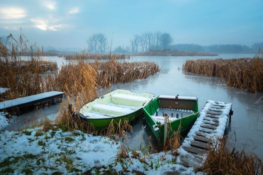 Boats on the shore of a frozen lake