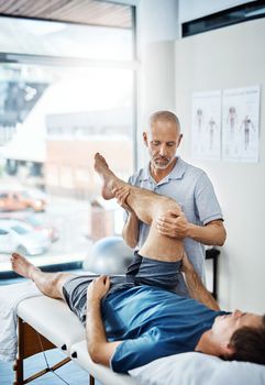 With careful exercises, your pain will soon be relieved. a physiotherapist treating a patient.
