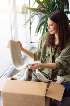 Woman excited to look trough her online order on winter clothes
