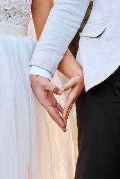 Love brought us together. an unrecognizable couple holding hands on their wedding day.