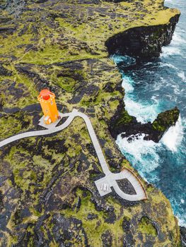 Vertical photo of bright orange Svortuloft Lighthouse on Snaefellsnes peninsula, Iceland