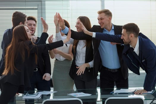 group of happy employees giving each other a high five.