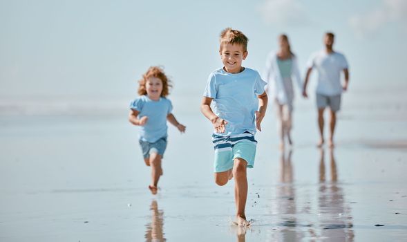 Children, running and beach with a brother and sister together on the sand by the sea or ocean during summer. Family, travel and fun with sibling kids on the coast with their parents for holiday