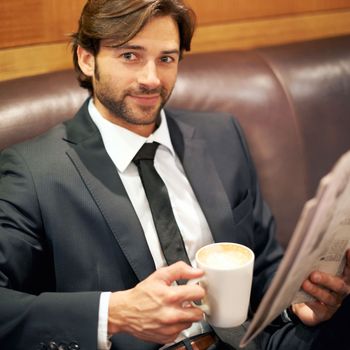 Every great day starts and ends with a good cup of coffee. A cropped portrait of a handsome businessman sitting on a couch in a coffee shop with a newspaper.
