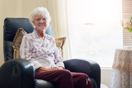 What a comfortable way to spend retirement. Portrait of a happy elderly woman relaxing on a chair at home.