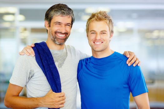 Happy friends after workout. Portrait of two male friends with arms around at health club.