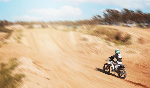 Sports, fitness and person with motorcycle, speed and action with power in desert, race or rally with athlete outdoor. Dirt bike, exercise and extreme sport mockup, freedom and adventure with travel
