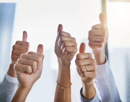 Showing you their approval. Closeup shot of an unrecognizable group of businesspeople showing thumbs up in an office.