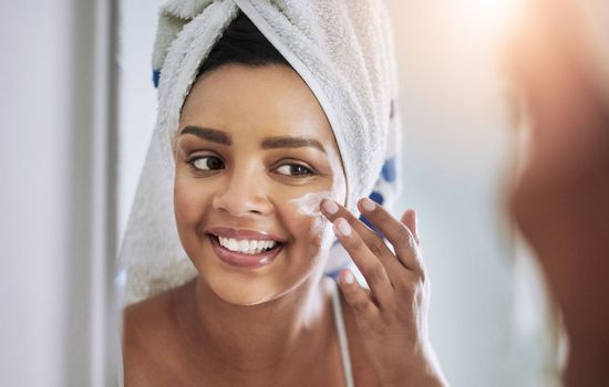 Give your skin the nourishment it loves. an attractive young woman applying moisturizer to her face in the bathroom.