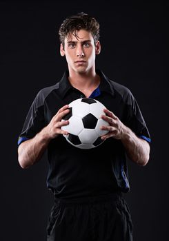 Play with heart. Portrait of a handsome soccer playing holding a ball.