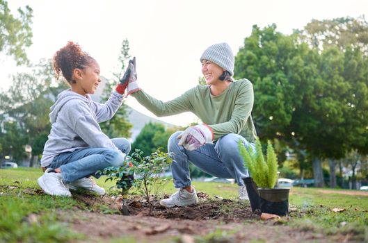 High five, child and woman with plant for gardening, ecology and agriculture in a park with trees. Volunteer family celebrate growth, nature and sustainability for community environment on Earth day