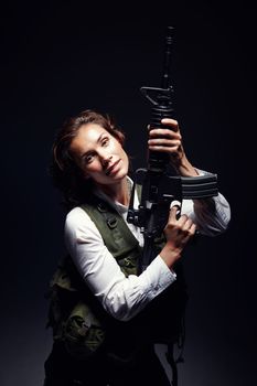 Powerful stance. Portrait of a woman wearing a safety jacket while standing and holding a rifle.