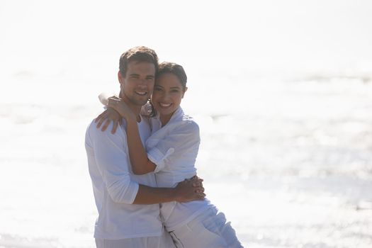 Sharing a loving gaze and a warm embrace. an affectionate young couple at the beach.