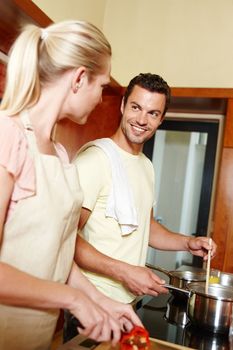 Cooking together creates a special bond. A husband and wife cooking together in the kitchen - domestic life.