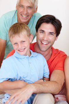 Family is the most important thing in the world. Portrait of a young man sitting with his son and his senior father at home