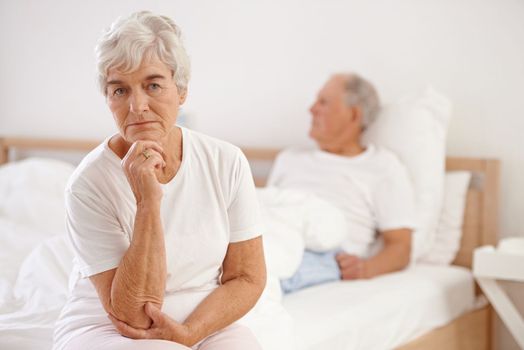 Arguments are a part of any relationship. a elderly couple looking unhappy in their bedroom.