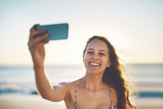 Ill get so many likes...a young woman taking a selfie on the beach.