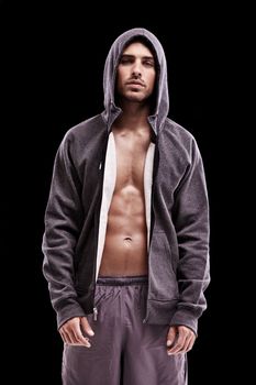 His focus is on total fitness. Studio shot of a bare-chested young man in sportswear standing confidently.