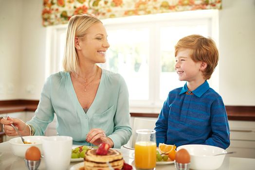 Sharing a nutritious and delicious breakfast together. a mother and son enjoying breakfast together at home.