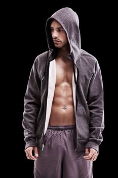 His focus is on total fitness. Studio shot of a bare-chested young in sportswear isolated on black.