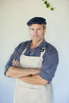 His knowledge and confidence makes him succesful. Portrait of a hansome mature man in an apron.